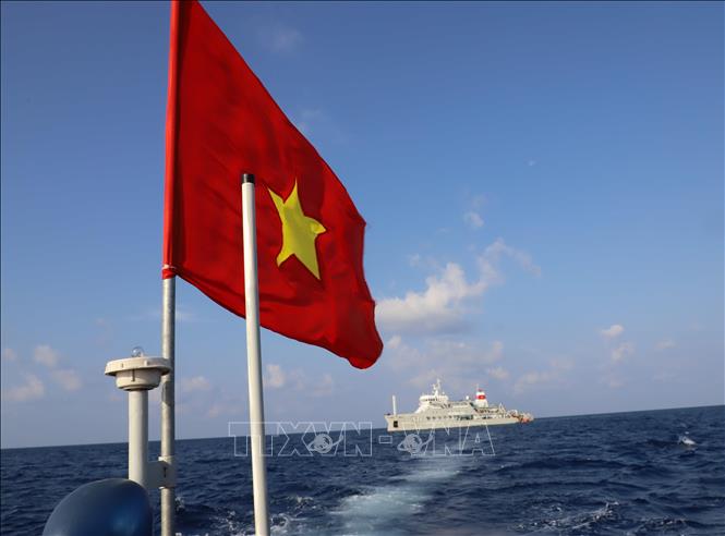 Trong ảnh: Cờ Tổ quốc tung bay trên nóc xuồng máy chở cán bộ, chiến sỹ từ tàu Trường Sa 571 lên đảo Song Tử Tây. Ảnh: Sỹ Tuyên – TTXVN