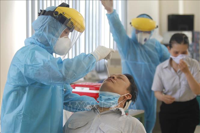 Trong ảnh: Các y bác sỹ Trung tâm y tế Quận 7 thực hiện xét nghiệm sàng lọc COVID-19 ngẫu nhiên cho công nhân tại Công ty TNHH Kim may Organ Việt Nam. Ảnh: Thanh Vũ - TTXVN
