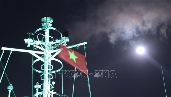 Trong ảnh: Cờ Tổ quốc trên nóc tàu Trường Sa 571 tung bay phấp phới dưới ánh trăng khi tàu đi trên vùng biển gần đảo Song Tử Tây – quần đảo Trường Sa (huyện Trường Sa, tỉnh Khánh Hoà). Ảnh: Sỹ Tuyên – TTXVN