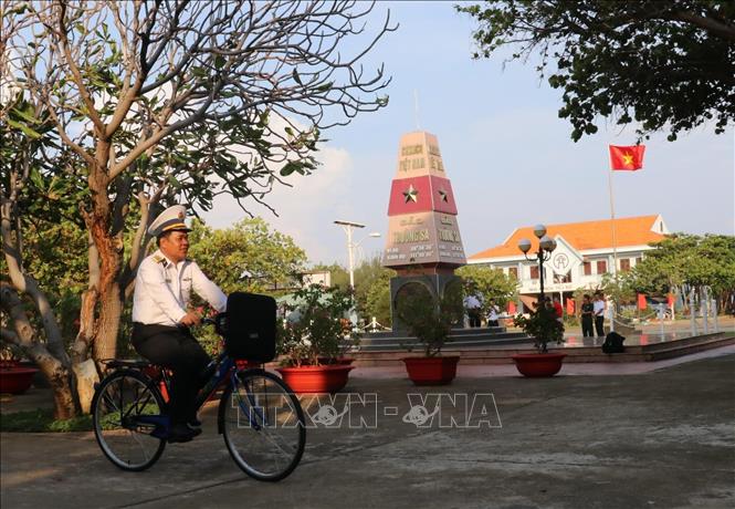 Trong ảnh: Đại tá Lê Đình Hải, Phó Lữ đoàn trưởng - Lữ đoàn 146 (vùng 4 Hải quân) đạp xe ngang qua cột mốc thị trấn Trường Sa (huyện Trường Sa, tỉnh Khánh Hoà). Ảnh: Sỹ Tuyên – TTXVN