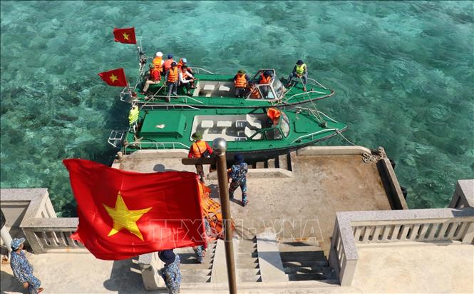 Trong ảnh: Cờ Tổ quốc tung bay phấp phới khi hai xuồng của tàu Trường Sa 571 cập mạn trên đảo Cô Lin. Ảnh: Sỹ Tuyên – TTXVN