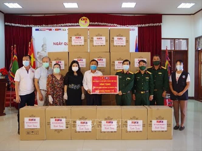 Trong ảnh: Đại diện Binh đoàn 11, Bộ Quốc phòng Việt Nam trao quà cho Tổng hội người Việt Nam tại Lào nhằm hỗ trợ phòng, chống dịch COVID-19. Ảnh: Thu Phương, phóng viên TTXVN tại Lào