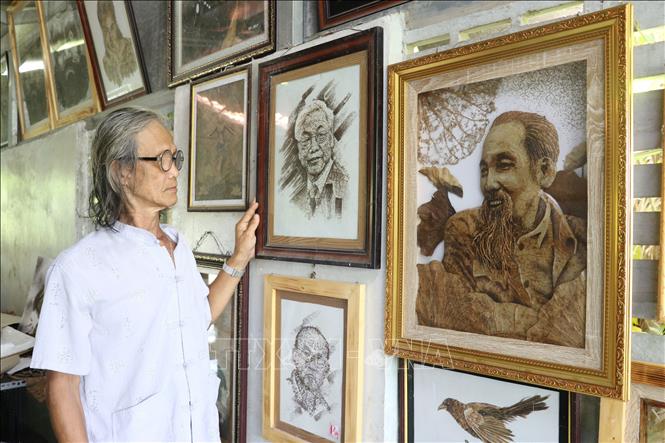 Trong ảnh: Các tác phẩm tranh từ lá sen của ông Bảy Nghĩa. Ảnh: Nguyễn Văn Trí - TTXVN