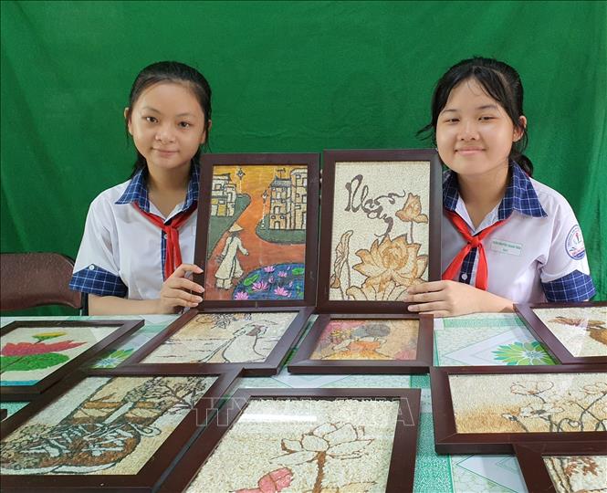 Trong ảnh:Hai chủ nhân của dự án bên các tác phẩm của mình. Ảnh: Ánh Tuyết - TTXVN