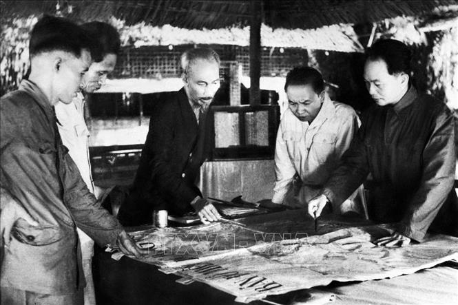 Cuối năm 1953, tại Việt Bắc, Chủ tịch Hồ Chí Minh và các đồng chí lãnh đạo Đảng quyết định mở chiến dịch Điện Biên Phủ. Trong ảnh: Bộ chỉ huy Chiến dịch Điện Biên Phủ: Chủ tịch Hồ Chí Minh (giữa), Đại tướng, Tổng tư lệnh Võ Nguyên Giáp (ngoài cùng bên phải) và các đồng chí trong Bộ Chỉ huy chiến dịch. Ảnh: Tư liệu TTXVN