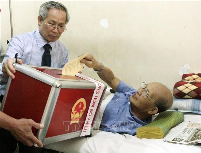 Trong ảnh: Tại đơn vị bầu cử số 4, phường Thanh Nhàn, quận Hai Bà Trưng (Hà Nội), tổ bầu cử phối hợp với Bệnh viện Thanh Nhàn trực tiếp đưa hòm phiếu lưu động đến tận các khoa, phòng nơi có các cử tri đang điều trị bệnh để thực hiện quyền và nghĩa vụ công dân, bầu đại biểu Quốc hội khóa XIII và đại biểu Hội đồng nhân dân các cấp nhiệm kỳ 2011 – 2016. Ảnh: Dương Ngọc – TTXVN