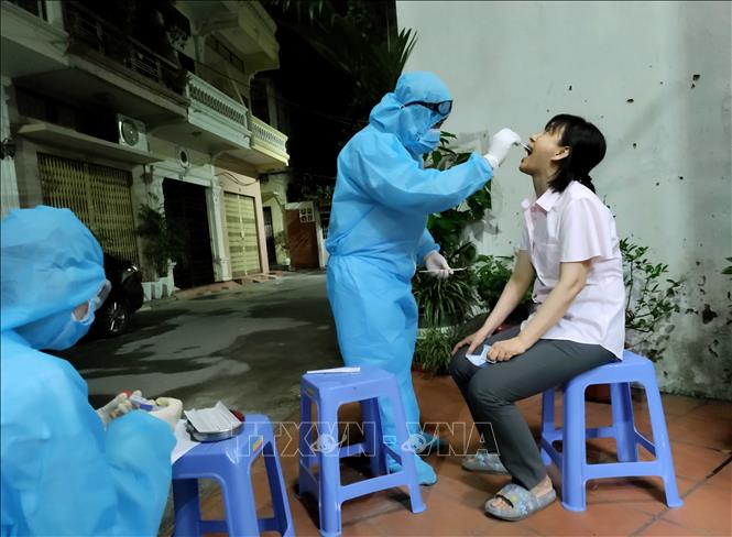 Trong ảnh: Lực lượng y tế chia từng nhóm nhỏ, đến từng địa chỉ ngay trong đêm để khẩn trương lấy mẫu xét nghiệm sau khi điều tra dịch tễ của bệnh nhân F0. Ảnh: An Đăng - TTXVN