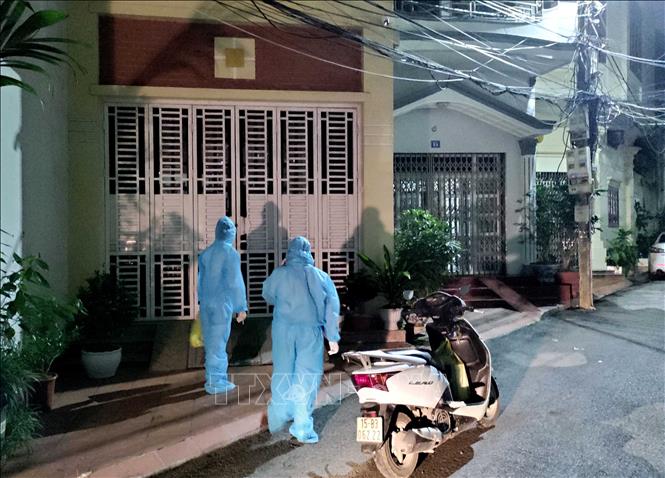 Trong ảnh: Lực lượng y tế chia từng nhóm nhỏ, đến từng địa chỉ ngay trong đêm để khẩn trương lấy mẫu xét nghiệm sau khi điều tra dịch tễ của bệnh nhân F0. Ảnh: An Đăng - TTXVN