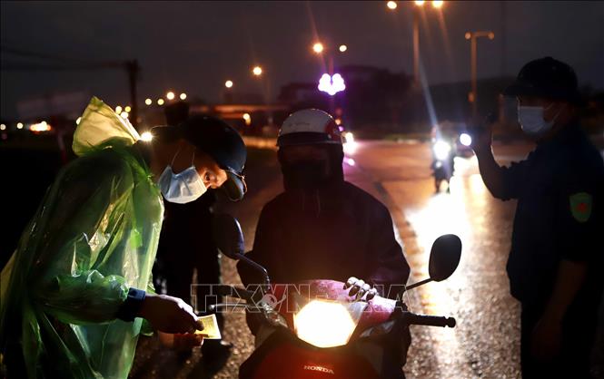 Trong ảnh: Những chiến sĩ thầm lặng làm việc dưới mưa tại chốt kiểm soát ở địa điểm Trạm thu phí quốc lộ 2 qua huyện Bình Xuyên. Ảnh: Hoàng Hùng- TTXVN 