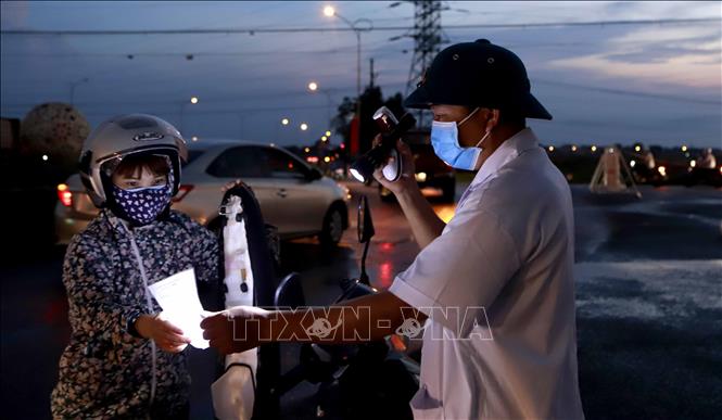 Trong ảnh: Kiểm tra giấy tờ xe chủ phương tiện tại chốt kiểm soát dịch bệnh COVID -19 tại chốt kiểm soát ở địa điểm Trạm thu phí quốc lộ 2 qua huyện Bình Xuyên. Ảnh: Hoàng Hùng- TTXVN 
