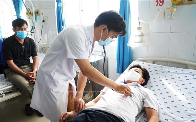 Lực lượng y tế kiểm tra sức khỏe cho người sau tiêm vắc xin COVID-19. Ảnh: Thanh Tân - TTXVN