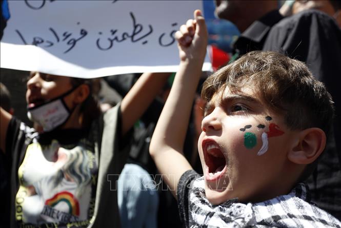 Trong ảnh: Trẻ em tại thành phố Nablus, Bờ Tây, tham gia tuần hành bày tỏ ủng hộ với người Palestine ở Dải Gaza, ngày 20/5/2021. Ảnh: THX/ TTXVN