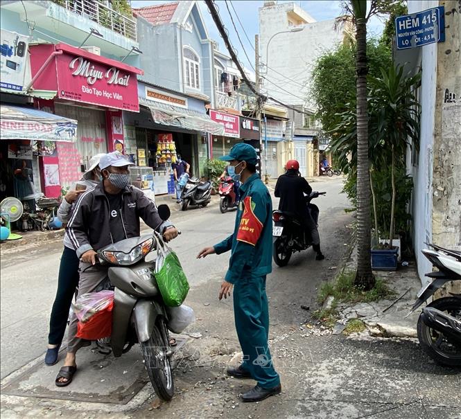 Trong ảnh: Lực lượng dân phòng tại hẻm 456 Nguyễn Văn Công (phường 3, quận Gò Vấp, Tp. Hồ Chí Minh) hạn chế người dân ra vào khu vực sinh hoạt của giáo phái truyền giáo Phục Hưng. Ảnh: Hồng Giang - TTXVN