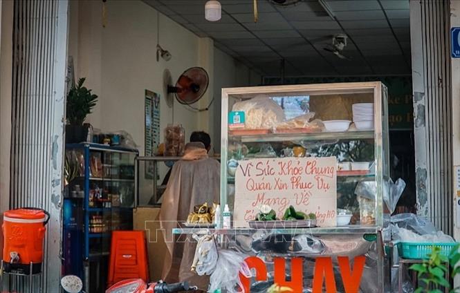 Trong ảnh: Một quán ăn trên đường Nguyễn Thượng Hiền (Quận 3, Tp. Hồ Chí Minh) gắn bảng phục vụ mang về. Ảnh: Hồng Giang - TTXVN