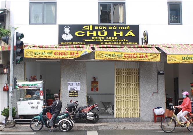 Trong ảnh: Một quán ăn trên đường Võ Văn Tần (Quận 3, TP Hồ Chí Minh) gắn bảng phục vụ mang về. Ảnh: Hồng Giang - TTXVN.
