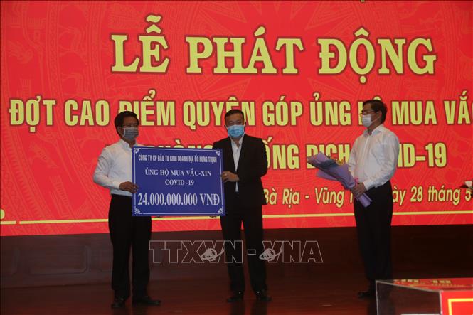 Trong ảnh: Đại diện doanh nghiệp trao bảng tượng trưng số tiền quyên góp tại lễ phát động. Ảnh: Hoàng Nhị - TTXVN