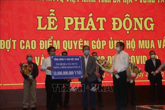 Trong ảnh: Đại diện doanh nghiệp trao bảng tượng trưng số tiền quyên góp tại lễ phát động. Ảnh: Hoàng Nhị - TTXVN