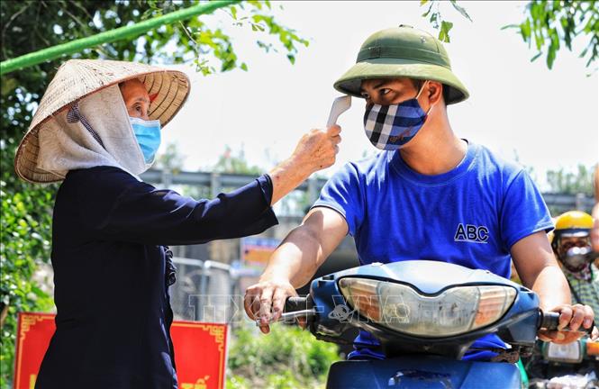 Trong ảnh: Các bà, các mẹ dù tuổi đã cao vẫn đội nắng tham gia gác chốt kiểm tra y tế giúp chính quyền huyện Đông Anh. Ảnh: Thành Đạt - TTXVN