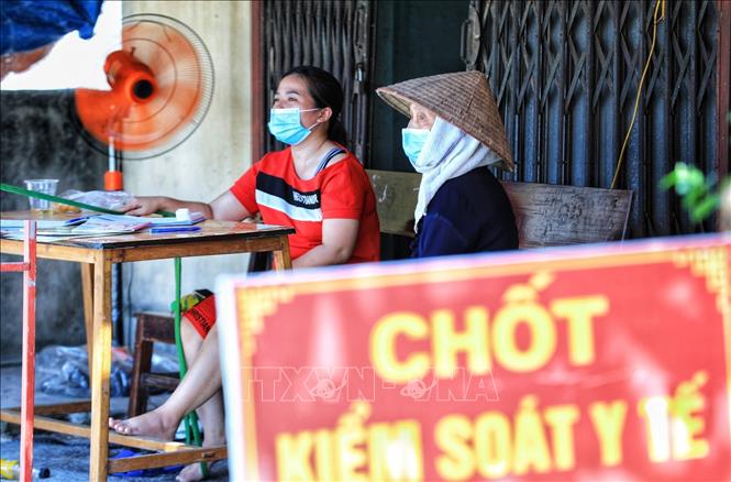 Trong ảnh: Dưới nhiệt độ nắng nóng gần 40 độ C, nhưng các tình nguyện viên là các bà, các mẹ trong hội Phụ nữ đều công tác phòng chống dịch của địa phương. Ảnh: Thành Đạt - TTXVN