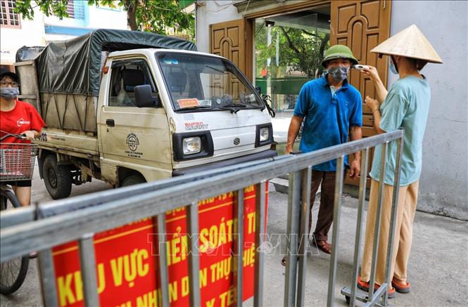 Trong ảnh: Các chủ phương tiện ra vào thôn đều phải xuống khai báo y tế, kiểm tra thân nhiệt cẩn thận. Ảnh: Thành Đạt - TTXVN