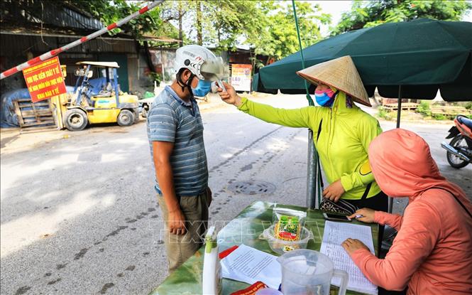 Trong ảnh: Các chị em trong hội Phụ nữ thôn Thiết Úng, xã Vân Hà, huyện Đông Anh có nhiệm vụ kiểm soát y tế, xác định lịch trình hoạt động của tất cả người và phương tiện đi vào địa bàn huyện. Ảnh: Thành Đạt - TTXVN