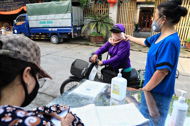Trong ảnh: Tại thôn Thù Lỗ, xã Liên Hà, huyện Đông Anh, các bà, các mẹ thuộc hội Phụ nữ túc trực chốt phòng dịch ghi lại lịch trình đi lại của những người lạ đi vào thôn. Ảnh: Tuấn Anh - TTXVN