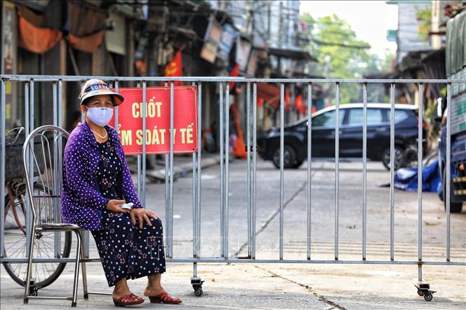 Trong ảnh: Dưới nhiệt độ nắng nóng gần 40 độ C, nhưng các tình nguyện viên là các bà, các mẹ trong hội Phụ nữ vẫn tham gia công tác phòng chống dịch của địa phương. Ảnh: Thành Đạt - TTXVN