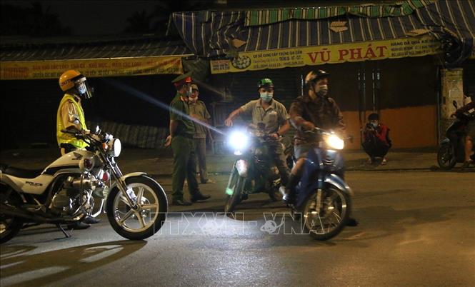 Trong ảnh: Lực lượng chức năng lập chốt kiểm soát lưu thông tại khu vực cầu Trường Đai giữa Phường Thới An, Quận 12 với Phường 13, Quận Gò Vấp. Ảnh: Xuân Tình - TTXVN