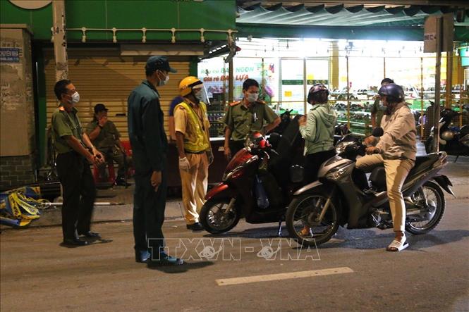 Trong ảnh: Lực lượng chức năng lập chốt kiểm soát lưu thông tại khu vực cầu Trường Đai giữa Phường Thới An, Quận 12 với Phường 13, Quận Gò Vấp. Ảnh: Xuân Tình - TTXVN