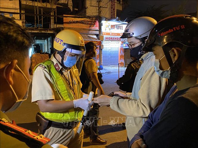 Trong ảnh: Lực lượng cảnh sát giao thông kiểm tra giấy tờ của người dân tại chốt kiểm tra trên đường Lê Quang Định (phường 1, quận Gò Vấp, Tp. Hồ Chí Minh). Ảnh: Hồng Giang - TTXVN.