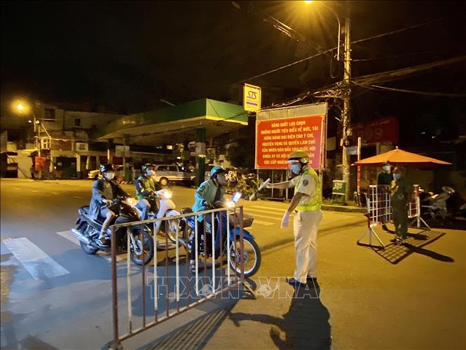 Trong ảnh: Lực lượng cảnh sát giao thông yêu cầu người dân dừng xe khai báo y tế trên đường Lê Quang Định (phường 1, quận Gò Vấp, Tp. Hồ Chí Minh). Ảnh: Hồng Giang - TTXVN.