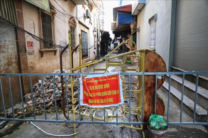 Trong ảnh: Người dân trong thôn lập hàng rào cứng cộng với xếp gạch và đồ đạc bỏ đi tạo thành những chốt chặn cứng. Ảnh: Thành Đạt - TTXVN