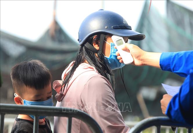 Trong ảnh: Những trường hợp dấu hiệu sốt thân nhiệt lên cao sẽ không được tiếp nhận qua chốt kiểm dịch giáp ranh giữa xã Vân Hà, Đông Anh với huyện Từ Sơn, Bắc Ninh. Ảnh: Tuấn Anh - TTXVN
