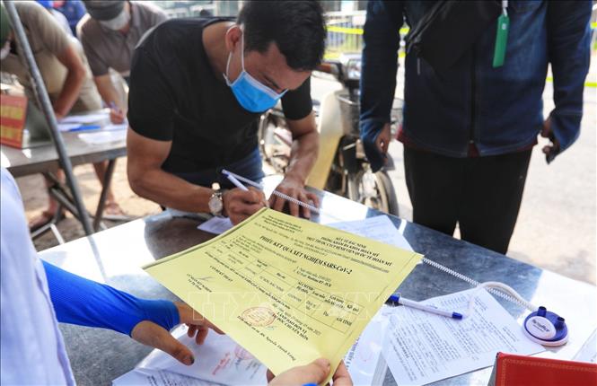 Trong ảnh: Một số người cung cấp xét nghiệm SARS-CoV-2 âm tính khi đi qua chốt kiểm dịch. Ảnh: Tuấn Anh - TTXVN