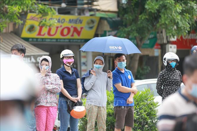 Trong ảnh: Phụ huynh có mặt ở cổng trường THPT chuyên Hoàng Văn Thụ thực hiện các quy định phòng chống dịch COVID-19. Ảnh: Trọng Đạt - TTXVN
