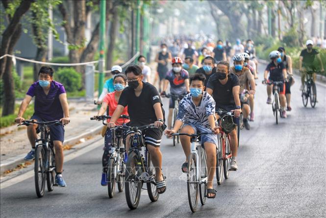 Trong ảnh: Mặc dù đã có cả biện pháp tuyên truyền và áp dụng phạt đối với nhiều trường hợp vi phạm, không đeo khẩu trang, nhưng theo cơ quan chức năng, rất khó để có thể dùng chế tài với hàng trăm người dân tập thể dục, đạp xe quanh Hồ Tây. Ảnh: Thành Đạt - TTXVN
