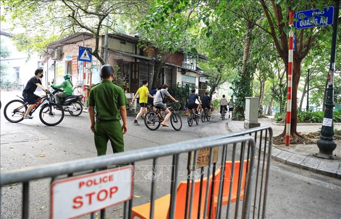 Trong ảnh: Lực lượng chức năng phường Quảng An lập chốt nhắc nhở, cấm người đi xe đạp, chạy bộ đi vào khu vực này. Ảnh: Thành Đạt - TTXVN