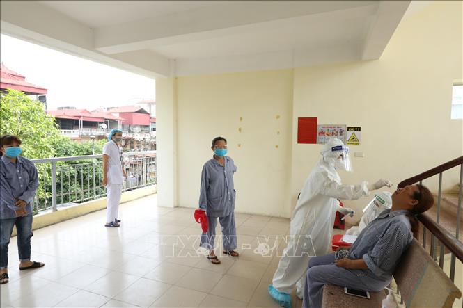 Nhân viên y tế lấy mẫu xét nghiệm COVID-19 cho bệnh nhân, người nhà tại các khoa, phòng. Ảnh: Minh Quyết - TTXVN