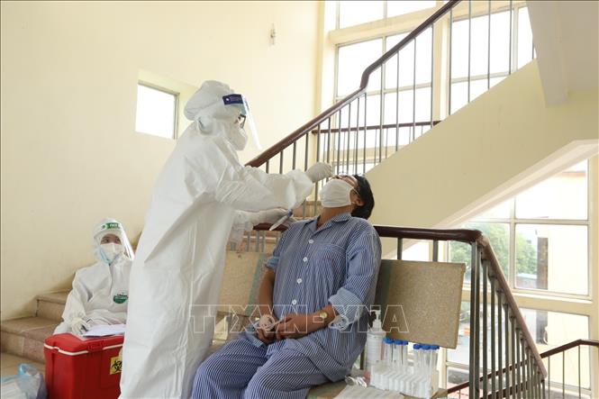 Nhân viên y tế lấy mẫu xét nghiệm COVID-19 cho bệnh nhân, người nhà tại các khoa, phòng. Ảnh: Minh Quyết - TTXVN