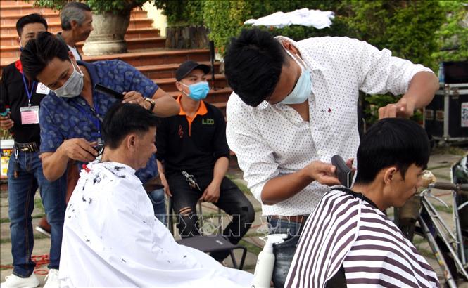 Trong ảnh: Người dân cắt tóc miễn phí tại “Phiên chợ không đồng” tổ chức tại Trung tâm bảo tồn di tích Hội An (Quảng Nam). Ảnh: Trịnh Bang Nhiệm - TTXVN