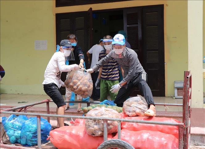 Trong ảnh: Đội ngũ tình nguyện viên chuyển thực phẩm từ các nhà tài trợ mang đến phát cho người dân tại xã Mão Điền (Bắc Ninh) đang thực hiện cách ly xã hội để phòng, chống dịch Covid -19. Ảnh: Thanh Thương - TTXVN