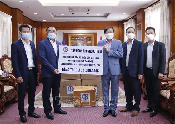 Trong ảnh: Chủ tịch Tập đoàn Phongsubthavy Phongsavath Senaphuan (trái) trao cho Đại sứ Nguyễn Bá Hùng tấm séc trị giá 500.000 USD ủng hộ Quỹ phòng, chống Covid của Việt Nam. Ảnh: Phạm Kiên - Phóng viên TTXVN tại Lào.