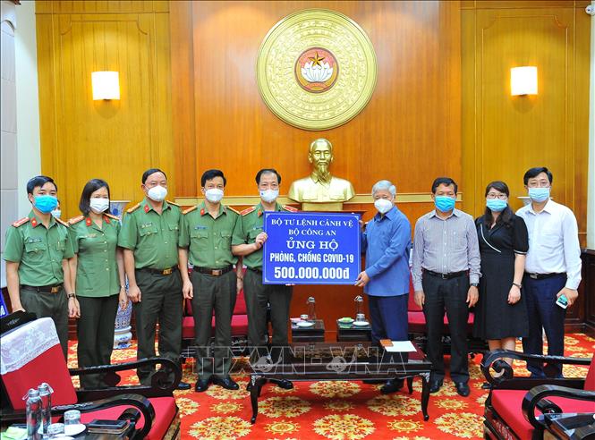 Chủ tịch Ủy ban Trung ương Mặt trận Tổ quốc Việt Nam Đỗ Văn Chiến tiếp nhận bảng tượng trưng số tiền 500 triệu đồng từ Thiếu tướng Trần Hải Quân, Tư lệnh Cảnh vệ. Ảnh: Minh Đức - TTXVN