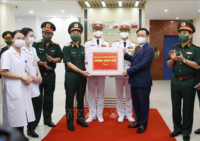Photo: NA Chairman Vuong Dinh Hue(2ndR) hands over gifts to the Academy's staff. VNA Photo: Doãn Tấn