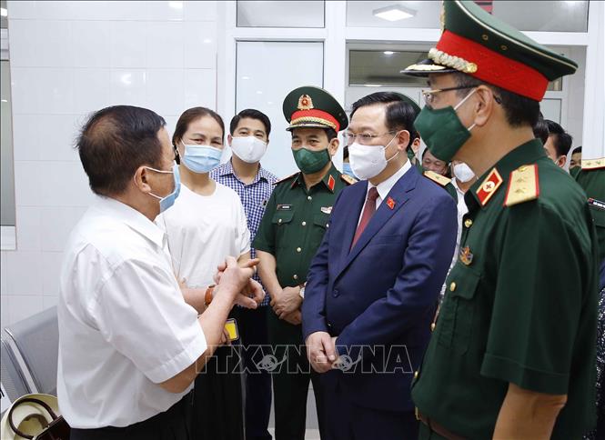 Photo: NA Chairman Vuong Dinh Hue (2ndR) talks with volunteers for clinical trial of made-in-Vietnam COVID-19 vaccine of Nanocovax at the Academy. VNA Photo: Doãn Tấn