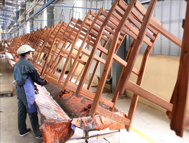 Photo: Putting final touches on wood articles for export to EU markets at the WOODSLAND Joint-stock Company in the northern mountainous province of Tuyen Quang. VNA Photo