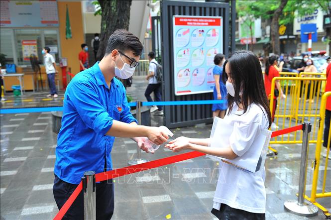 Đoàn thanh niên Đoàn phường Hàng Bài xịt khử khuẩn cho các thí sinh tại điểm thi trường THCS Ngô Sĩ Liên, quận Hoàn Kiếm để phòng, chống COVID-19.Ảnh: Minh Đức - TTXVN