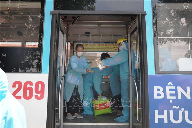 Người lao động từ vùng dịch Bắc Giang về tỉnh Vĩnh Phúc được khử khuẩn trước khi xuống xe. Ảnh: Nguyễn Thảo – TTXVN