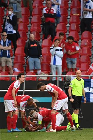 Trong ảnh: Các tuyển thủ Đan Mạch bên tiền vệ Christian Erikssen khi anh ngã gục trên sân trong trận gặp đội Phần Lan ở bảng B, EURO 2020 trên sân Parken, Copenhagen ngày 12/6/2021. Ảnh: AFP/TTXVN