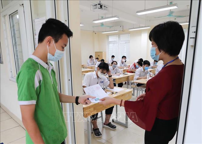 Trong ảnh: Kiểm tra thẻ dự thi của thí sinh trước khi vào phòng thi tại điểm thi trường THPT Trần Nhân Tông. Ảnh: Thanh Tùng - TTXVN